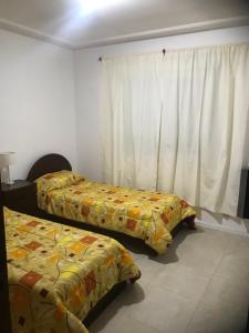 里奥夸尔托Departamentos modernos en Rio Cuarto Yrigoyen的一间卧室设有两张床和窗户。