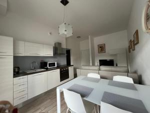 加尔达湖滨Appartamento Noi Due的厨房配有白色的桌子和白色的橱柜。