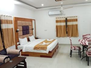 SankarankovilAruna Residency的卧室配有一张床和一张桌子及椅子