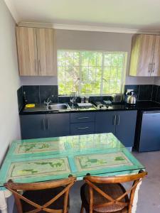 希尔顿Cachai Cottage的厨房配有玻璃桌和水槽