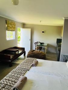 希尔顿Cachai Cottage的一间带两张床和一张桌子的卧室以及一间厨房