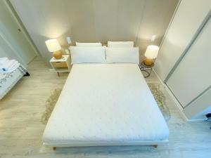 里斯本Airport Lisbon Guest House的一张大白床,位于带两盏灯的房间