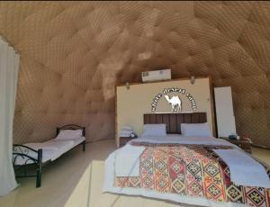 瓦迪拉姆White Desert Camp的卧室配有一张床,墙上有标志