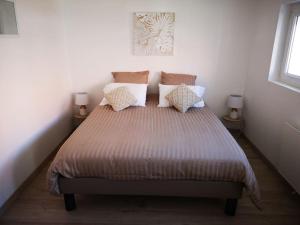 维桑T3 - Appartement jardin Wissant 6 personnes的一间卧室配有一张带枕头的大床