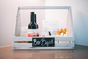 卢加诺Bigatt Hotel & Restaurant的一瓶葡萄酒和木板箱上的标志