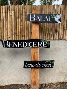 BacnotanBalai Benedicere Bed & Breakfast的 ⁇ 旁的木杆上标有标志