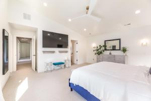 盐湖城BRAND NEW Modern 5 Bd, 3 Story Home in Sugarhouse!的白色卧室设有一张大床和一台平面电视。