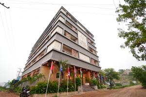 海得拉巴Mevid Hotels的前面有旗帜的大建筑