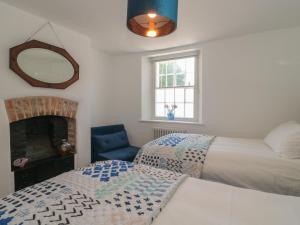 多切斯特Mollys Cottage的一间卧室配有两张床和镜子
