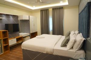 海得拉巴Mevid Hotels的一间卧室配有一张大床和电视