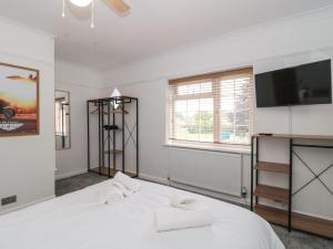 伯翰姆昂斯Seabar的卧室配有白色的床和平面电视。