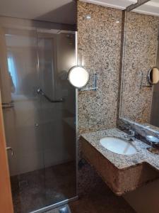 巴西利亚Lets Idea Hotel Flat Particular的一间带水槽和玻璃淋浴的浴室