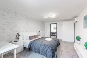 布达佩斯Deluxe Quentin Apartment next to the Heroes Square的一间卧室设有一张床和白色的墙壁
