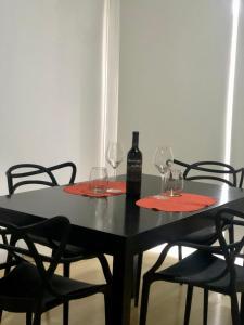 瓜伊马延Departamento de Noah的一张带两杯酒和一瓶葡萄酒的黑桌