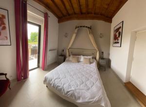 BerbiguièresDomaine des Mauves的卧室配有一张白色大床和木制天花板