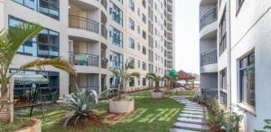 内罗毕JVhomes2bedroom-Ndemi gardens的棕榈树公寓庭院和游乐场