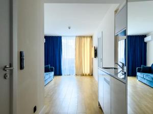 巴统ORBI CITY Beautiful Luxurios Panoramic View on batumi的厨房以及带蓝色窗帘的起居室。
