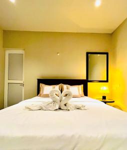 尼甘布Ceylon Kingsmen Garden Hotel - Katunayake的一间卧室配有一张带白色床单的大床