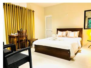 尼甘布Ceylon Kingsmen Garden Hotel - Katunayake的一间卧室配有大床和黄色窗帘