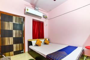 HājīpurSPOT ON Hotel Vivek的小房间,配有带丰富多彩枕头的床