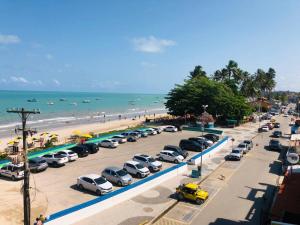 马拉戈日Fabika Pousada的海滩旁的停车场停放着一捆汽车