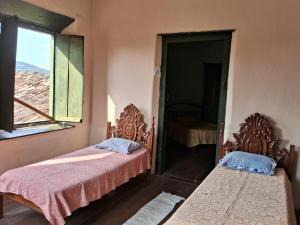 戈亚斯Casa por temporada的带窗户的客房内的两张床