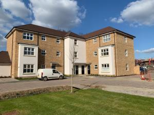 彼得伯勒Peterborough City Center One Bed apartment With Free Private Parking的前面有一辆白色面包车的建筑