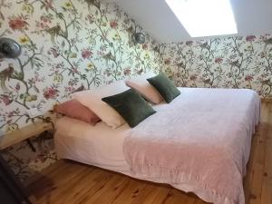 塔布La Maison de Sylvie, chambres d'hôtes à Tarbes的一间卧室配有一张带花卉壁纸的床