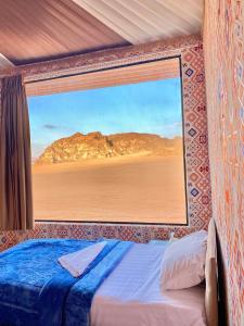 瓦迪拉姆WADi RUM ALi CAMP的卧室设有窗户,享有沙漠美景