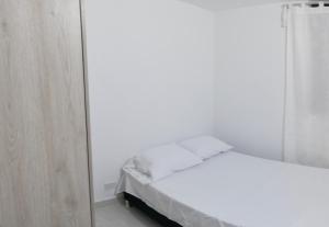 内瓦Apartamento Neiva的白色卧室配有床和镜子