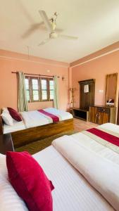 奇旺Hotel Tree Tops- A Serene Friendly Hotel in Sauraha的一间卧室配有两张带红色枕头的床