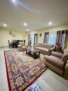 斯利那加The Khayabaan - Luxurious Home Stay Away From Home的带沙发和桌子的客厅以及地毯。