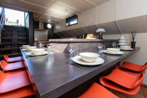 科尔马LA PENICHE的用餐室配有红色椅子和长桌