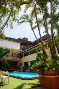 亚松森Hotel Santo Domingo的一个带游泳池和棕榈树的度假村