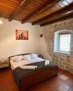 波雷奇Holiday Houses Luan的一间卧室设有一张床和石墙