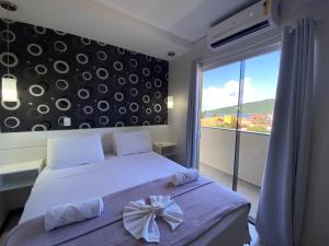 弗洛里亚诺波利斯Parada Beach Beira-Mar e Aptos 70m do Mar的一间卧室,配有一张床,床上有一个弓