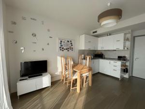 佩罗Stupendo appartamento in Fiera Milano-Up Town的厨房配有桌椅和电视。