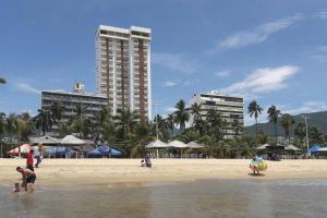 阿卡普尔科Luxurious Apartment, Oceanfront, spectacular view的一群人在海滩上建有建筑物