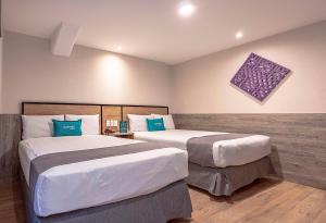 墨西哥城Ayenda Continental Mexicano的酒店客房 - 带两张带蓝色枕头的床