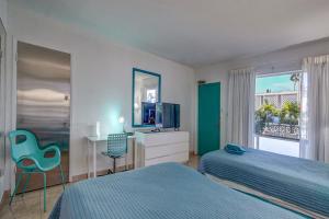 劳德代尔堡海之地平线旅馆的一间卧室配有两张床、一张桌子和一台电视。