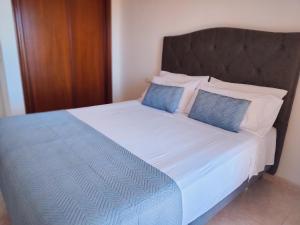 滨海罗克塔斯Villa Sara Holidays的床上有2个蓝色枕头