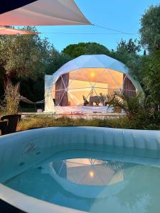 伊特里Glamping Domes San Martino的庭院里一个大帐篷,有水池