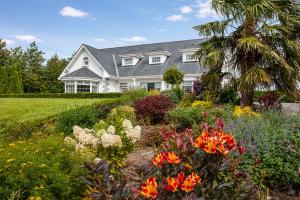 纽布里奇The Ridgewood Lodge的前面有一座开满鲜花的花园的房子