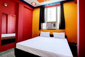 加济阿巴德OYO Hotel Sk Inn的卧室拥有红色和黄色的墙壁,配有一张床