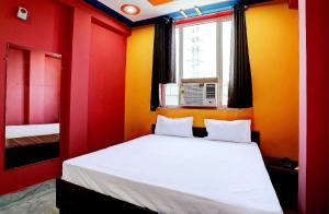 加济阿巴德OYO Hotel Sk Inn的卧室拥有红色和黄色的墙壁,配有一张床