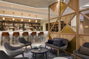 伦敦Courtyard by Marriott London City Airport的餐厅内的酒吧,配有桌椅