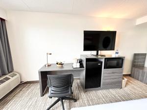 锡达拉皮兹Kiteville Cedar Rapids的客房设有书桌、电视和椅子