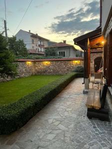 BratsigovoGuest House EGO的一个带石墙和长凳的花园