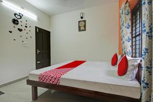 阿勒皮OYO Flagship Sanvilla的一间卧室配有红色枕头的床