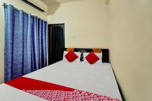 巴特那OYO Flagship Residence Inn Guest House的一间卧室配有红色和白色枕头的床